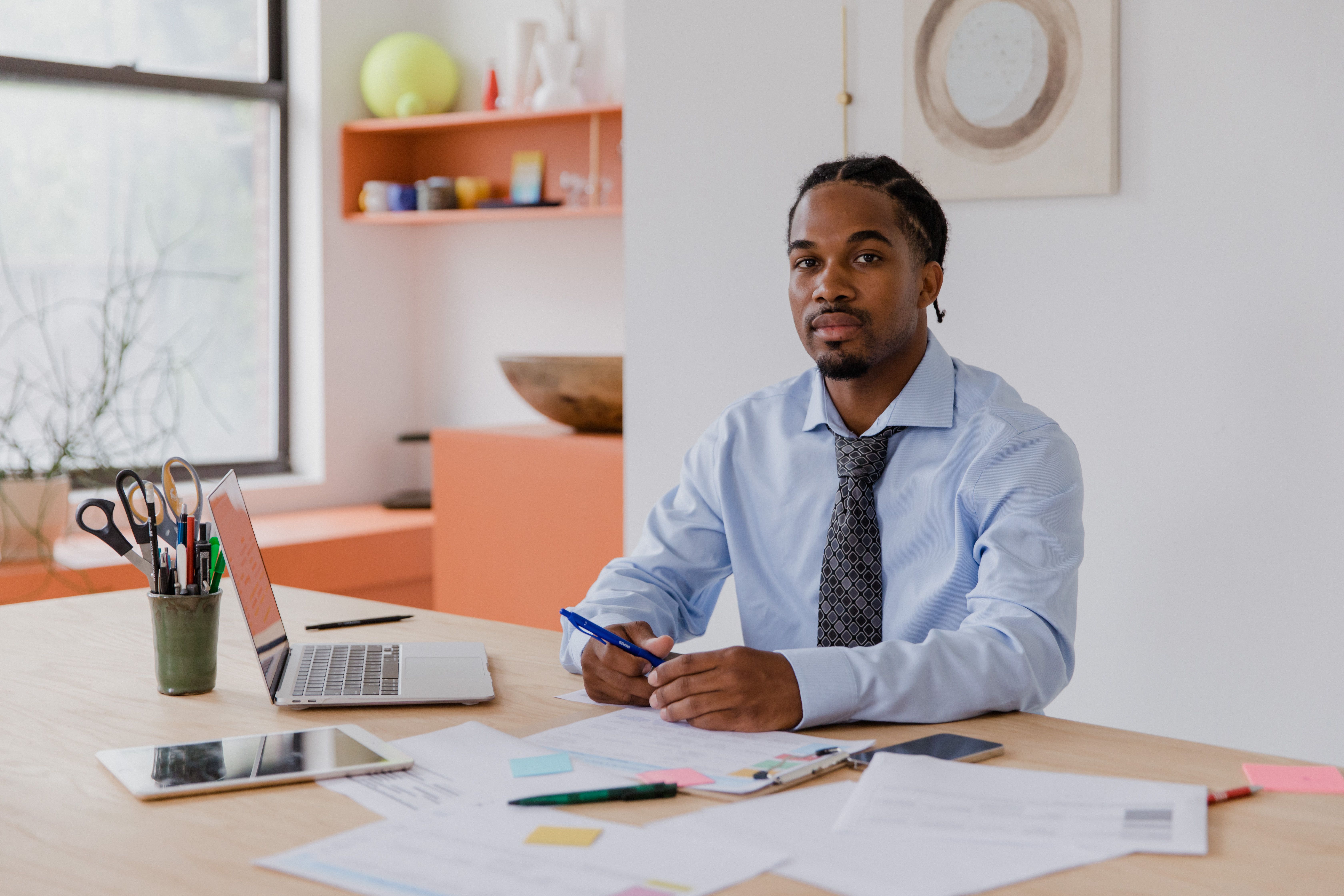 Business owner working alone at a desk with a laptop and documents, representing DIY SEO efforts
