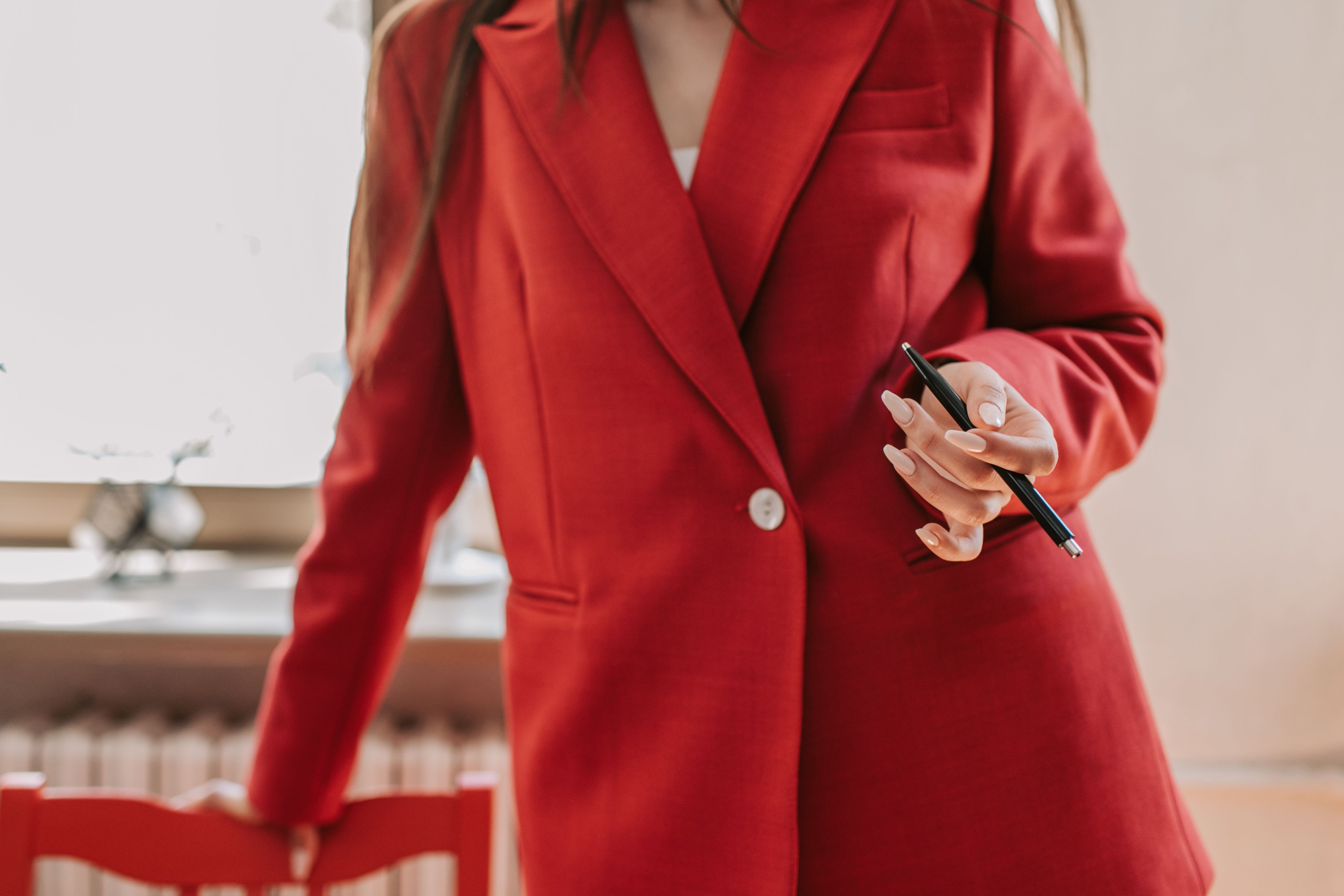 Confident woman in a red blazer exuding business power and dominance