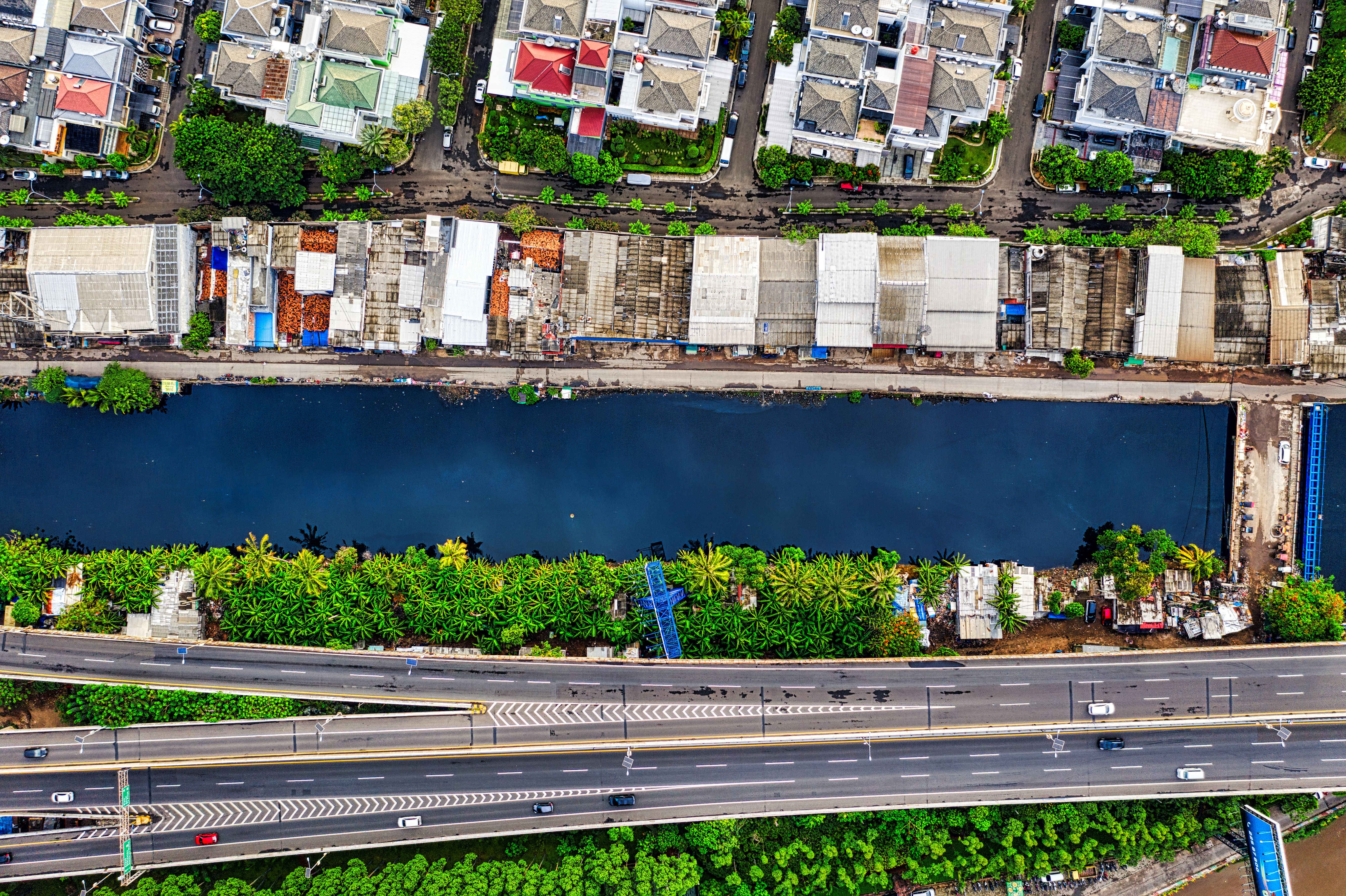 Aerial view of Jakarta's neighborhoods, river, and highway showing urban growth