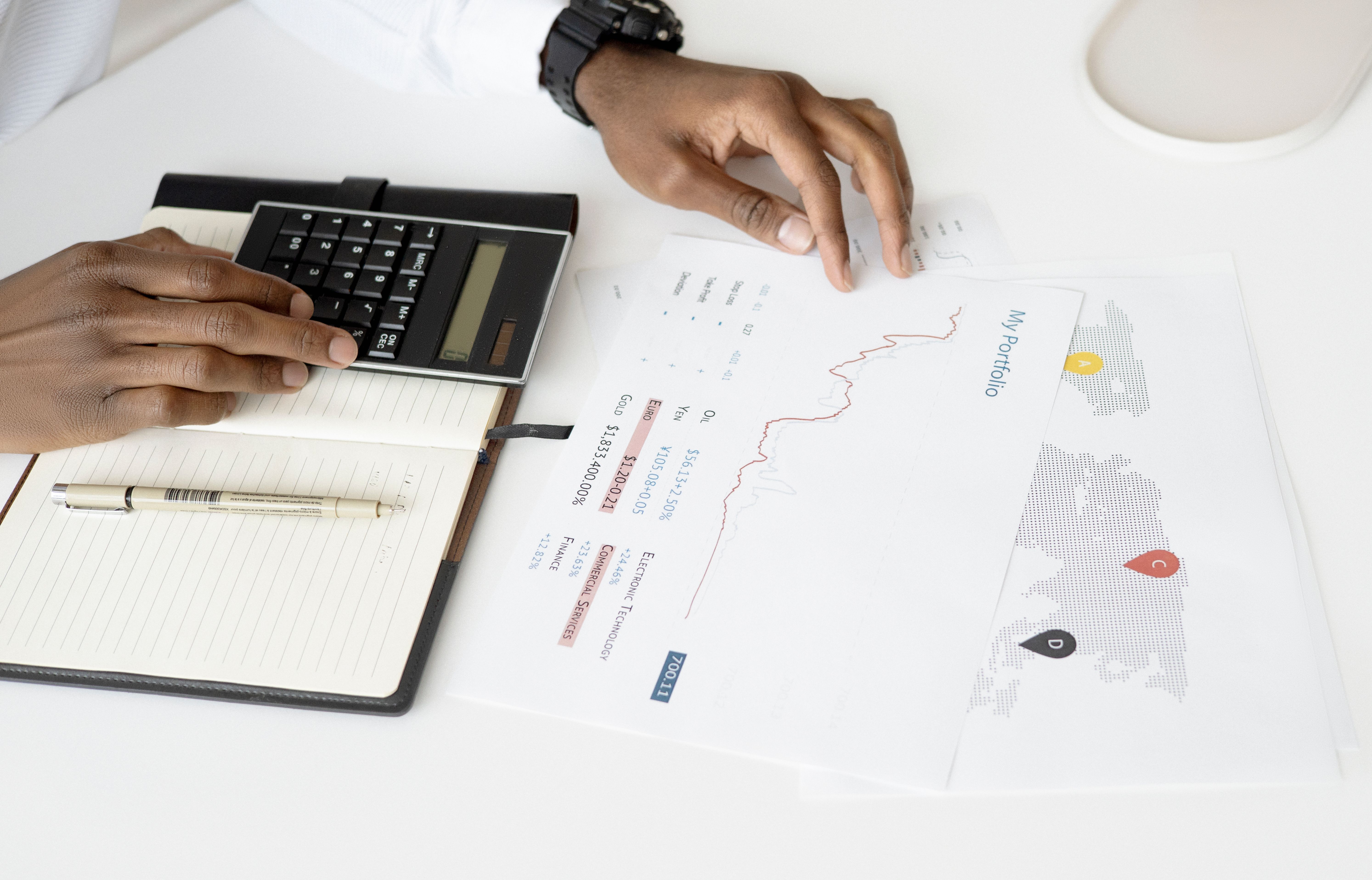 Person analyzing financial documents with a calculator for investment planning